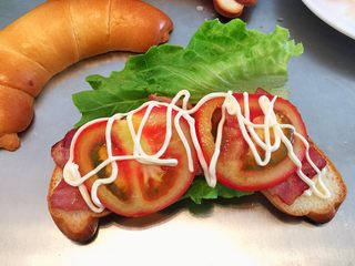 16、牛角汉堡,在牛角包上挤上蛋黄酱，放上生菜，培根，番茄，再挤上蛋黄酱