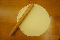 10、黑橄榄培根虾仁披萨,发好的面团排气，用擀面杖擀成25厘米左右的饼皮