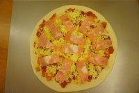 14、黑橄榄培根虾仁披萨,铺入培根片，铺上圆椒、玉米粒、黑橄榄