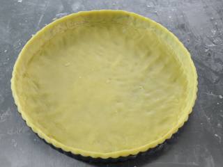 6、布丁水果派,把擀好的派皮均匀的放入派模中，派皮表面用针轮打孔；