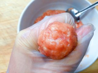 13、萝卜肉丸汤,开始下肉丸，用虎口挤出肉丸，然后用勺子挑到锅里。