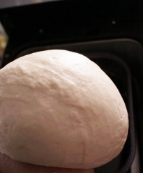 3、香煎紫薯薄饼,取一小匙橄榄油,将面团表面和盆中都抹上,加盖松弛约30分钟