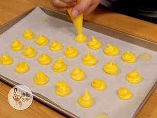 15、让世上没有难做的泡芙,接着把面团挤在烘焙纸上，挤的时候要挤得高一点，这样烤的时候才更好膨胀起来，我挤的比较迷你，你可以挤得大一点