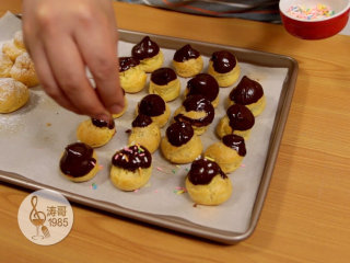 31、让世上没有难做的泡芙,最后可以在香草味的泡芙上洒一层糖霜以及在巧克力味的泡芙上洒一些彩色糖针做装饰就大功告成了