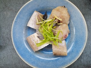 11、蒸鳕鱼,把腌好的鳕鱼上面撒上葱丝