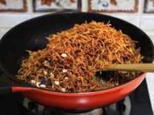 10、苕丝糖,倒入炸好的红薯丝、花生、黑加仑,迅速翻拌一下,关火;