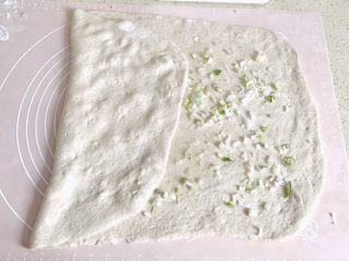 13、麦麸葱油花卷,为了更均匀，扯着面皮的一边，压到中间，按压几下，摊匀葱油