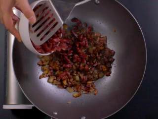 6、萝卜糕,将锅加油烧热后,放腊肉和腊肠爆炒,待脂肪部分变透明,加入瑶柱和虾米碎