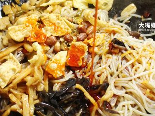 8、干炒好欢螺螺蛳粉丨大嘴螺,将木耳丝,酸笋、酸豆角、腐竹花生放入锅中,再浇上红油。每次看见这艳丽的红,就忍不住悄悄咽口水~