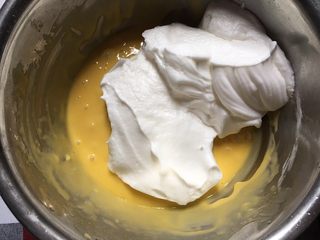 7、咖啡戚风蛋糕,将1/3的蛋白加入到蛋黄糊里，并搅拌均匀，翻拌和切拌手法