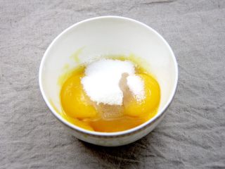 1、杯子羊蛋糕,蛋黄蛋白分开放在无油无水的容器内,蛋黄碗内放入细砂糖和香草精,隔热水用手动打蛋器搅打均匀后备用;