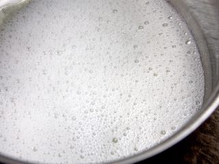 2、杯子羊蛋糕,另取一个容器,分三次放入15g细砂糖,用电动打蛋器第一次打到鱼眼发泡后放1/3细砂糖,第二次打到粗泡沫时再放1/3细砂糖;