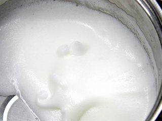 3、杯子羊蛋糕,打到蛋头提起后蛋白呈弯曲小角再放入余下的细砂糖,继续打到蛋头提起后蛋白呈现尖角后停止;