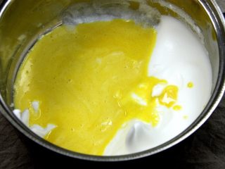 5、杯子羊蛋糕,将拌匀的蛋黄糊全部倒回蛋白中,用橡皮刮刀由下向上轻轻翻拌几下,不用全部翻拌均匀;