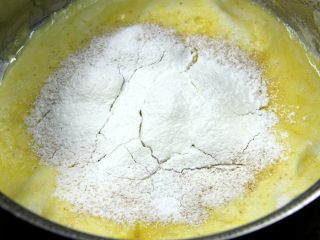 6、杯子羊蛋糕,筛入低筋面粉和玉米淀粉,用橡皮刮刀继续翻拌到均匀;