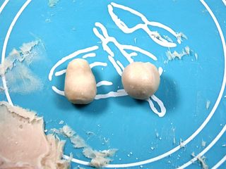 12、杯子羊蛋糕,将白巧翻拌成形,用棉签沾取少量玫红色素晕染白巧成淡淡的肉粉色后,双手沾取熟玉米淀粉取一部分白巧捏出形状;