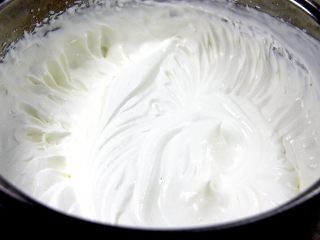 15、杯子羊蛋糕,取一个无水无油的容器倒入淡奶油和细砂糖,用电动打蛋器搅打到蛋头提起呈尖角状态,表示打发合适;