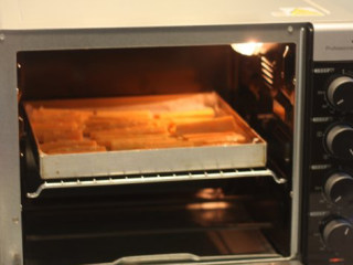 4、【桂花蜂蜜红薯条】,烤箱上下火200度预热好，把红薯条放入烤箱中层，烘烤15分钟