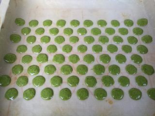 16、抹茶波点蛋糕卷,裱花袋剪一个小口，小点就好，太大不好掌握。在铺了油纸的烤盘挤出波点（可以提前画好，或电脑打印好）。放入预热好的烤箱烘烤1分钟即可。