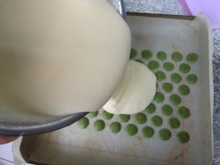 18、抹茶波点蛋糕卷,在烘烤好的波点上面倒入蛋糊，刮刀抹平。