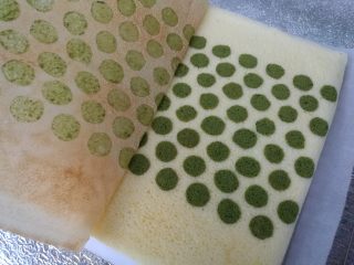 21、抹茶波点蛋糕卷,用一张新的油纸盖在蛋糕上，翻过来，揭开油布，然后再翻过来，用揭开的油布盖住蛋糕。