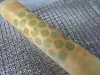 22、抹茶波点蛋糕卷,借助油纸卷成卷，送入冰箱冷藏定型。