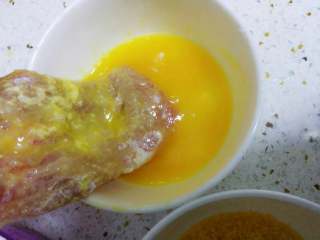 2、猪排饭,然后裹上鸡蛋液。