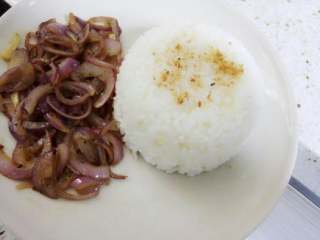 7、猪排饭,盘里准备好米饭(可洒些芝麻做装饰),将黑胡椒洋葱摆在饭旁边。