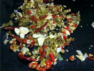 7、川菜芋儿鸡,另起油锅,放入干辣椒,花椒炒香后,再放入泡菜炒香;放入葱末,姜末,蒜瓣继续翻炒;