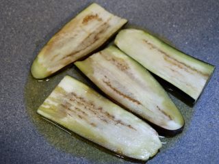 8、西蓝花洋葱茄子煲 ,锅内倒入食用油,烧至八成热,下入茄子块,注意把茄子有皮的一面贴着锅煎,一边煎一边用铲子把茄子里的水按出去。