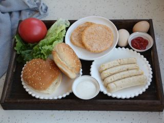 1、鸡肉玉米香肠汉堡,准备好食材：汉堡胚子、自制太阳谷鸡肉玉米香肠、黄金鸡肉饼、鸡蛋、番茄、生菜、番茄沙司、沙拉酱。食材可就地取材，喜欢吃什么就放什么。