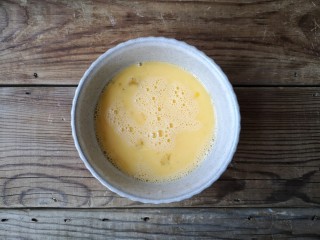 3、洋葱木耳炒鸡蛋#吃出好身材#,鸡蛋磕入碗中打散成蛋液。