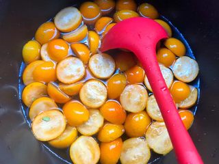 5、金桔酱,待冰糖完全融化，倒入切好的金桔，大火煮至水开。