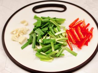 2、韭菜炒豆芽,红椒去筋洗净用刀切成条，韭菜切掉，大蒜切薄片。