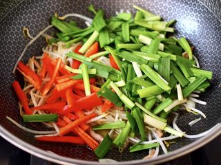 13、韭菜炒豆芽,加入红椒条和韭菜段。