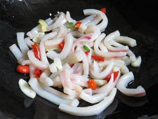 7、鱿鱼炒冬瓜皮,倒入鱿鱼条和辣椒翻炒2分钟