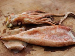 2、空气炸锅鱿鱼圈????【宝宝辅食】,洗净后的鱿鱼放在菜板上、鱿鱼头不用、可以和其它食材烹制