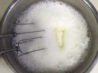 9、低温原味戚风,用手动打蛋器搅拌蛋白,打至出现鱼网状泡沫时,加入1/3细砂糖。