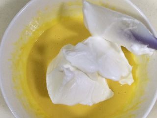 13、低温原味戚风,把蛋白糊分三次加入蛋黄糊内,用刮刀翻拌均匀。