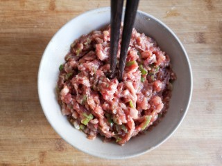 4、糖醋东北肉签子,用筷子顺一个方向搅拌,搅上劲儿(筷子能立在肉馅中不倒)。