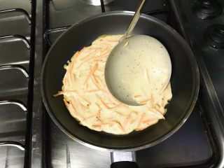 14、做饼+黑胡椒胡萝卜煎饼,用勺子迅速挤压面糊,让面糊均匀铺在锅底。