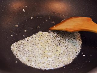 10、金针酸汤肥牛,锅中油烧热，放入姜末和蒜末爆香。