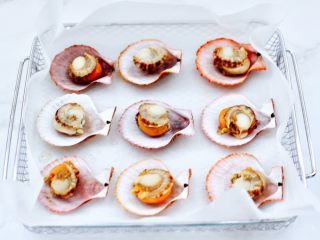 4、蒜蓉剁椒烤扇贝,把扇贝肉的内脏,清理干净后再冲洗干净,码放在扇贝壳上。