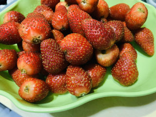 2、????自制草莓酱????,把草莓蒂一个个摘下来；