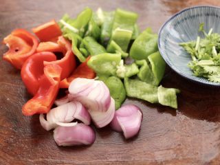 2、荷塘月色小炒,青椒和红椒用刀切片，洋葱切片，香菜切段。