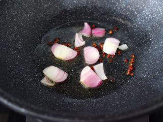 5、荷塘月色小炒,锅烧热后，倒入花生油烧至六成热时，小火慢慢炒香花椒，再大火爆香洋葱。