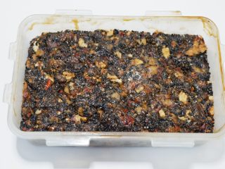 17、阿胶糕固元膏,密封盒多抹点芝麻油,把固元膏倒入,平铺均匀,用擀面棍压平压实。