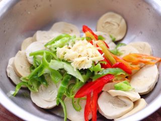 6、豆腐卷凉拌三椒,把焯过水的豆腐卷放入盆中，上面放入切丝的柿子椒和红椒，黄椒和蒜泥。