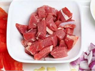1、牛肉炖柿子,牛肉切大块、洋葱切小丁、西红柿切块、大蒜拍下。