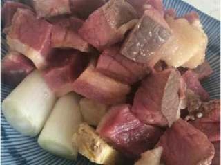 2、牛肉炖柿子,牛肉需要焯一下，去沫。同时，锅放在中火倒入黄油融化。